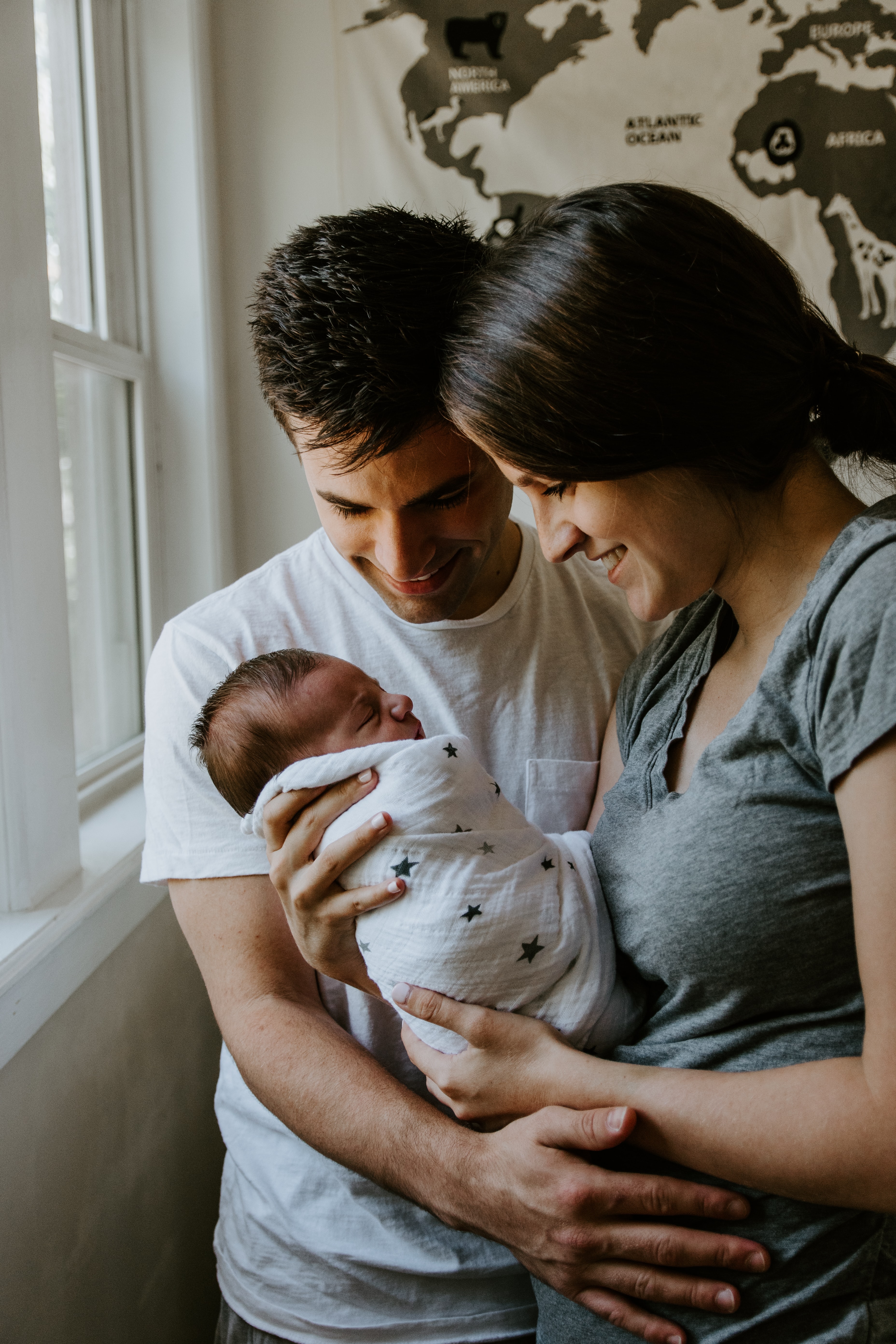 The picture shows two parents holding an infant.