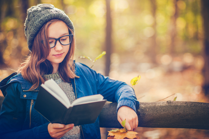 Jente leser i park. foto: Getty