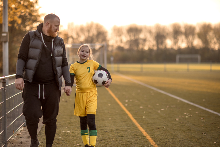 far og datter på fotballbane