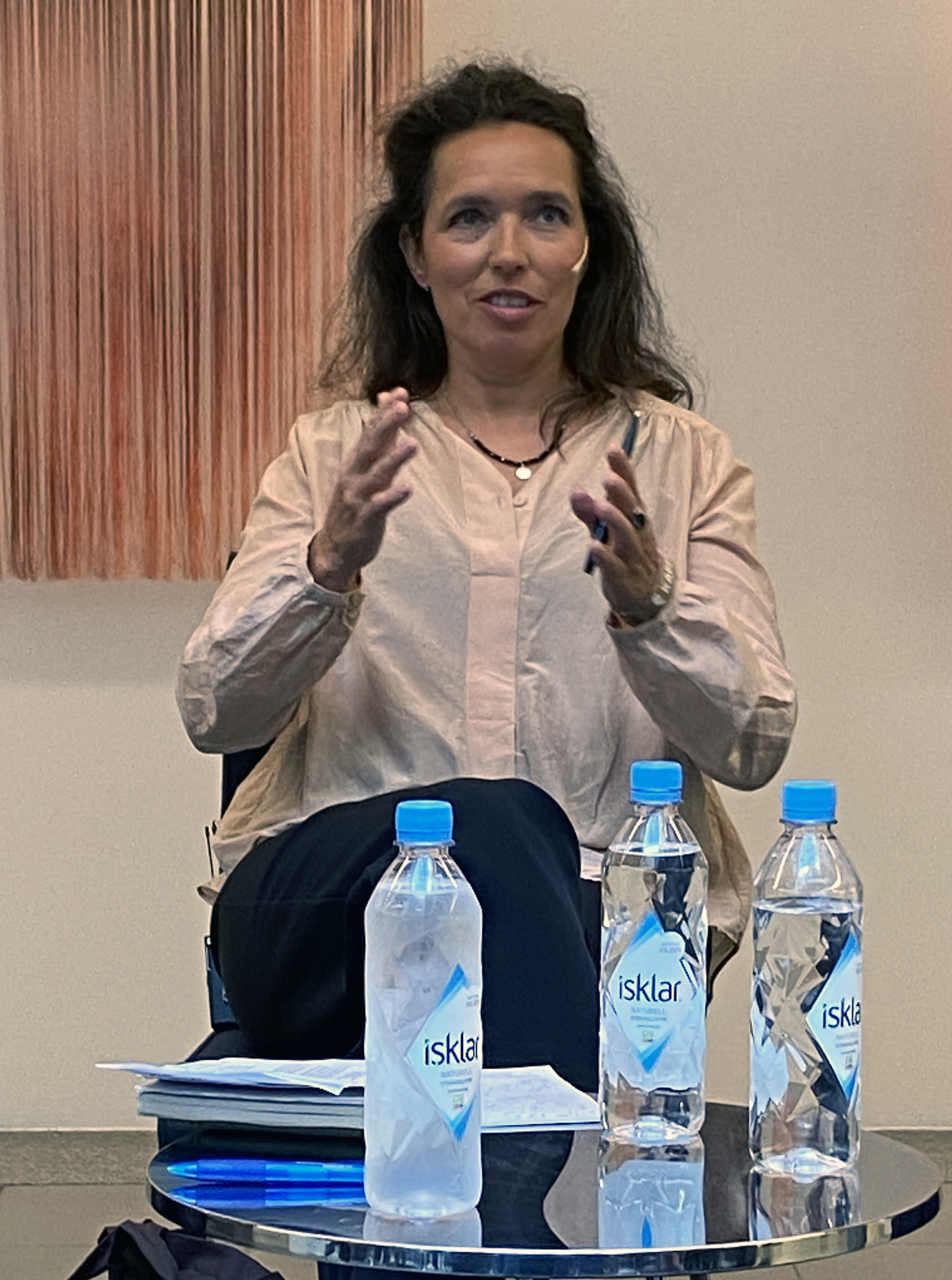 Lady gesturing at an event.