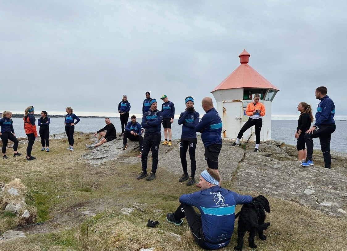 folk i løpesko og -klær, fyrlykt, svaberg, horisont ut mot havet