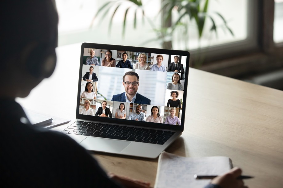 Kvinne med ryggen til i team-møte på laptop