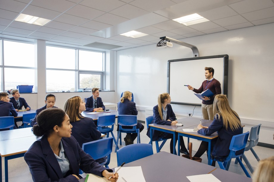 Lærer står foran elever i klasserom