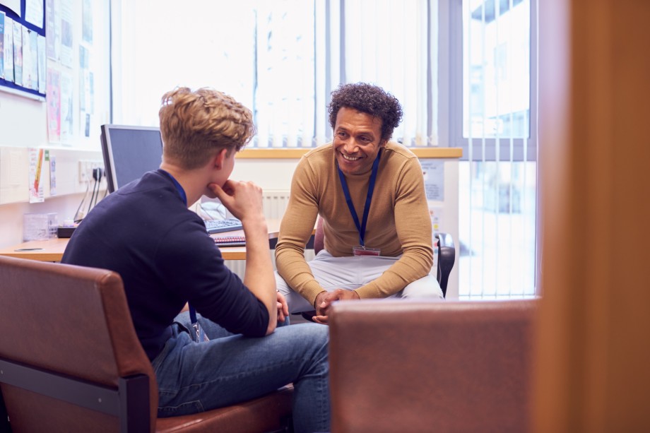En rådgiver sitter og snakker med en mannlig student
