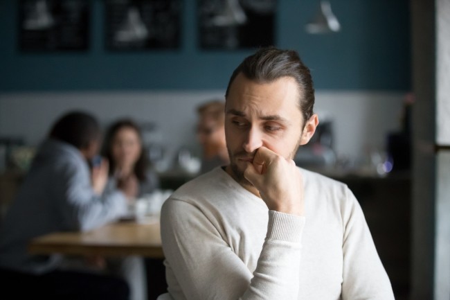 Voksen person sitter og ser litt bekymret ut